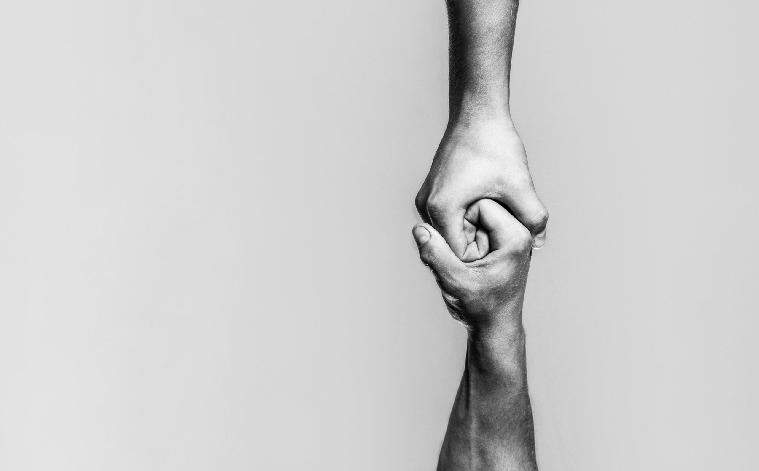 Two hands, helping arm of a friend, teamwork. Helping hand concept and international day of peace, support. Black and white.